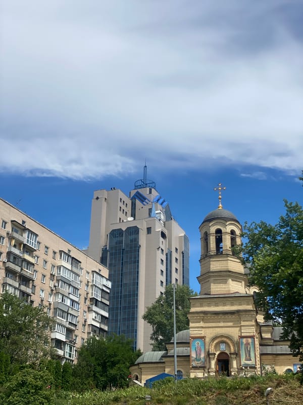 Golden-crossed bell tower rises against a clear blue sky
