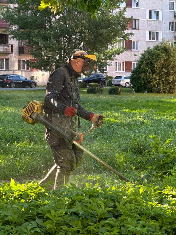 Resident performs lawn maintenance with safety gear in Riga