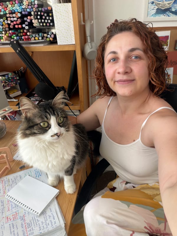Woman takes selfie with cat at art desk in Bat Yam
