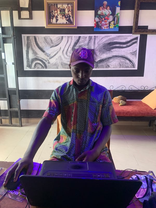 Man editing images on laptop at desk in Jos