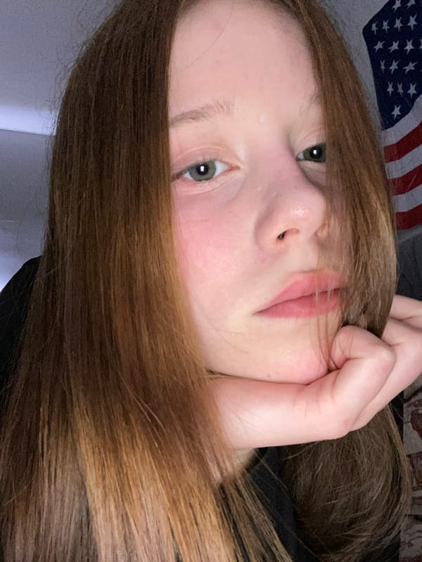 Young person takes playful selfies with American flag backdrop