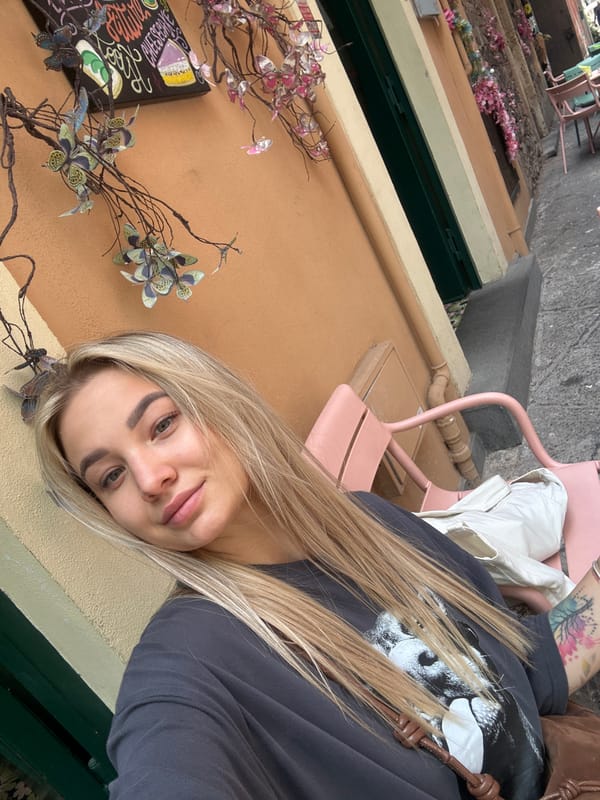 Woman captures selfie on flower-decorated Catania street