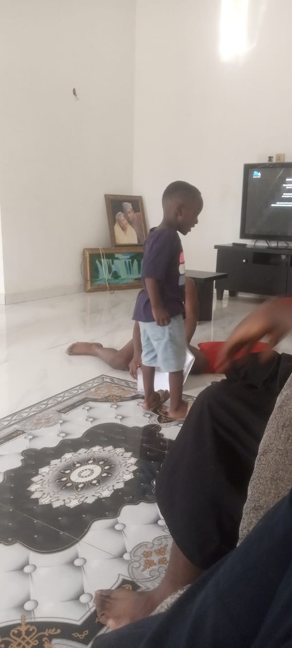 Child observed standing near person lying on floor indoors