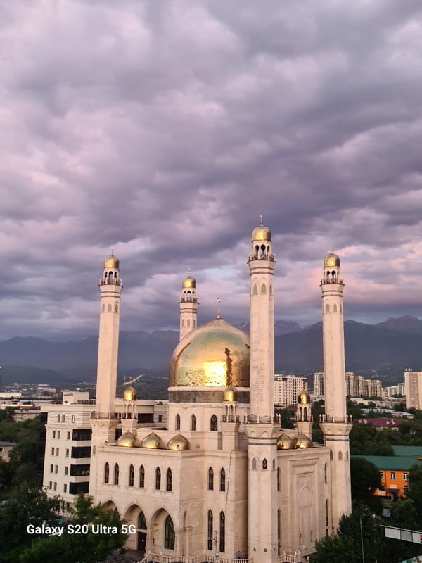 Almaty's Central Mosque glows at dusk with mountain backdrop