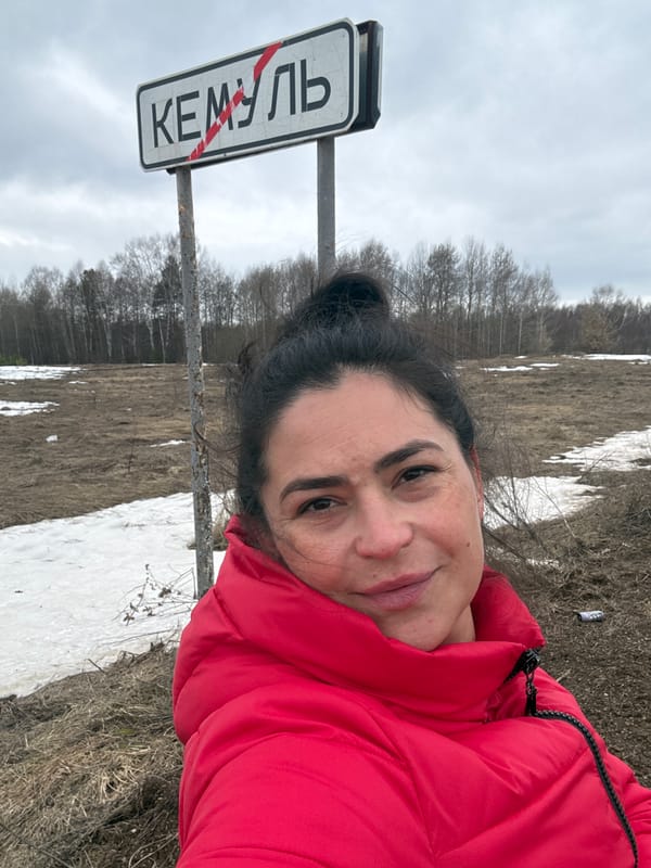 Woman photographed at Kemul city sign during early spring
