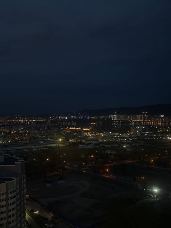 Nighttime cityscape views captured from indoor window in Krasnoyarsk