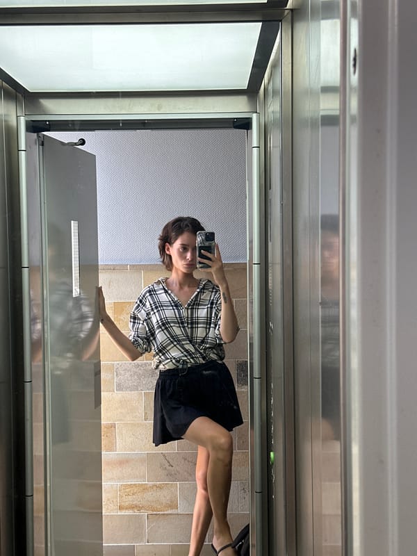 Mirror selfie in a Kiel elevator, checkered shirt and steel walls.