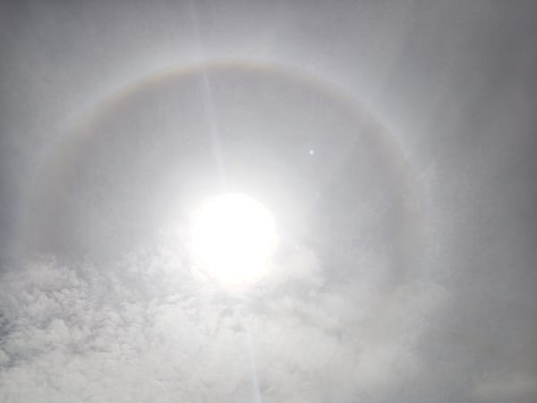 Sun halo creates rainbow ring in cloudy sky