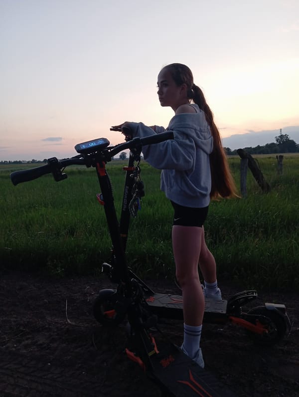 Evening scooter stop in Polish countryside, wildflowers in hand