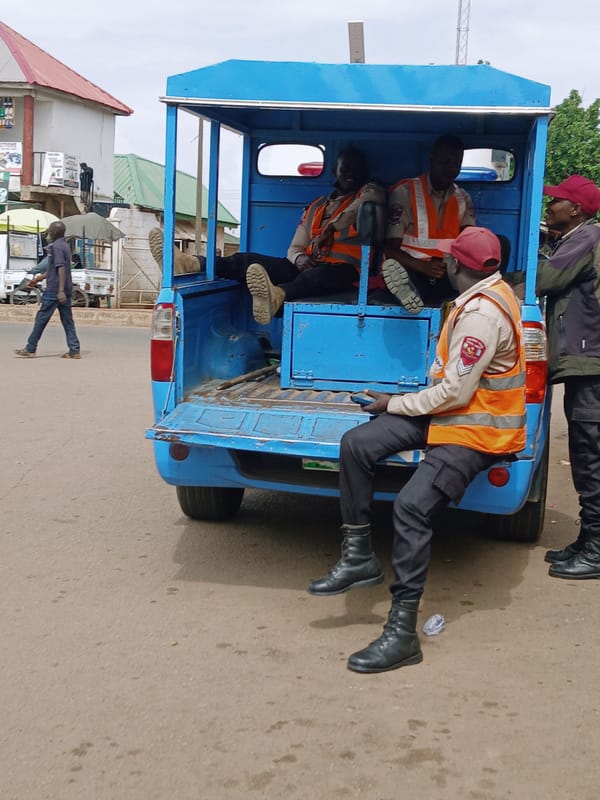 Blue vehicle carries passengers in orange vests, red hats
