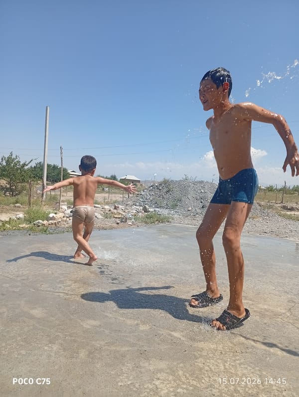 Kids playing in water on a sunny day in Kyrgyzstan