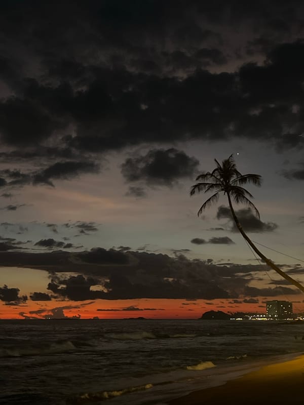 Dramatic sunset contrasts with storm clouds over Rumassala, Sri Lanka