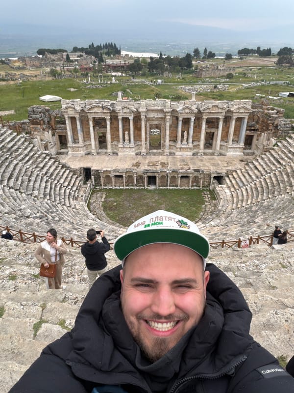 Tourist visits ancient Hierapolis theater, paraglider spotted over Pamukkale