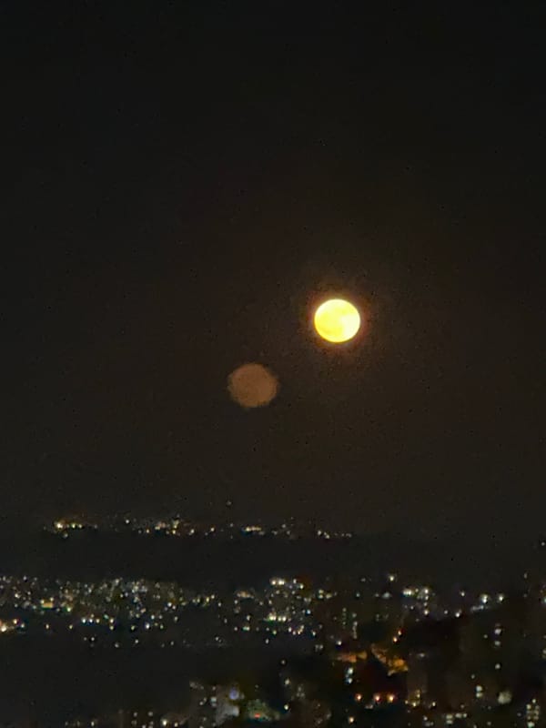 Haifa at night — full moon, city lights, and the port below