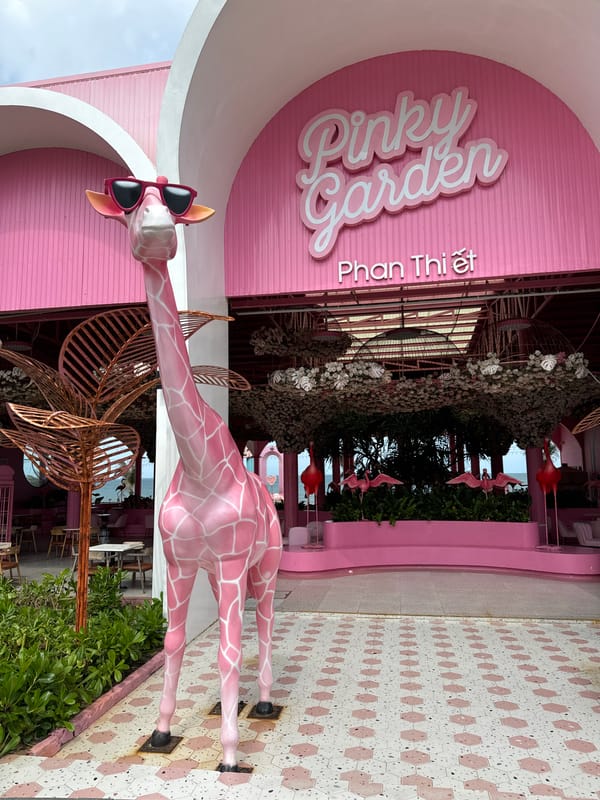 Visitors document pink-themed Pinky Garden cafe with giraffe statues