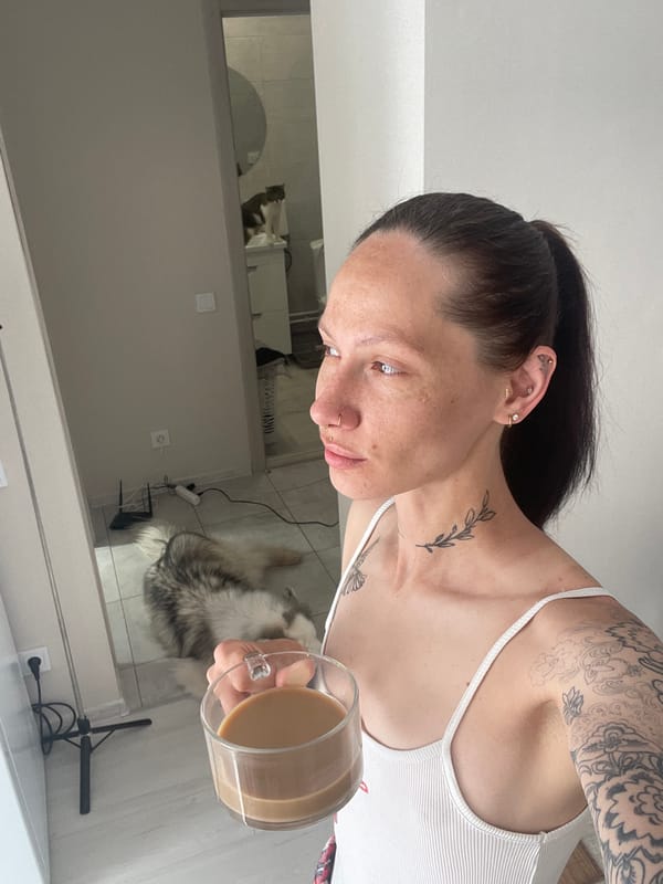 Woman with coffee, cat on windowsill captured in Izhevsk