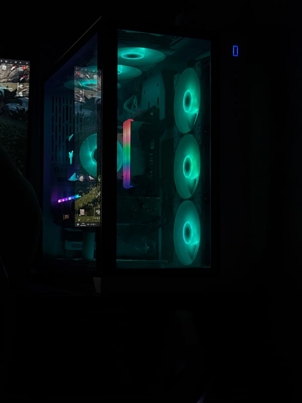 RGB gaming PC setup with a rainy street view outside
