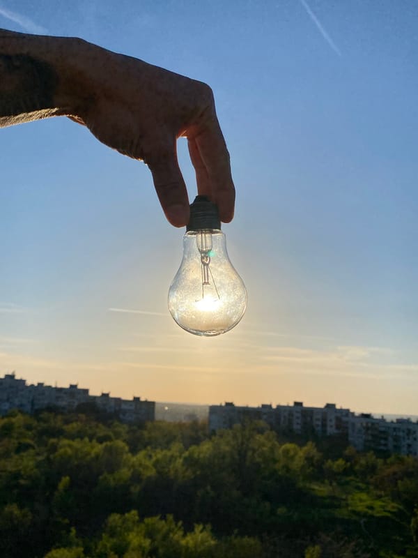Hand holds lightbulb capturing sunlight in Pleven, Bulgaria