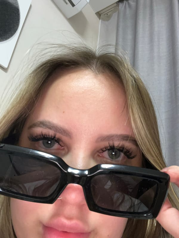 Woman photographed with sunglasses, smartphone in Krasnodar evening