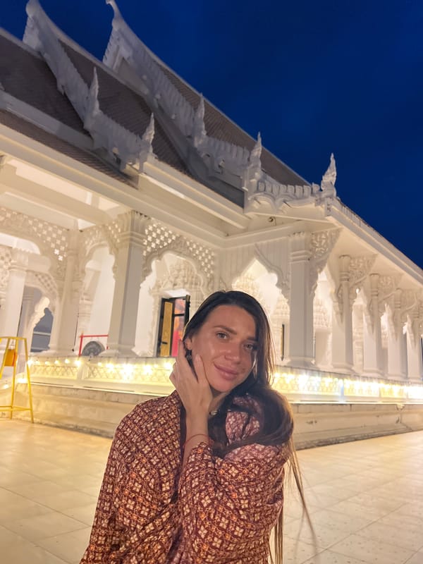 Tourist poses for photos at Thai temple complex
