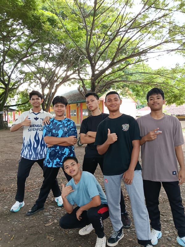Young males gather in formation outdoors in Lhokseumawe