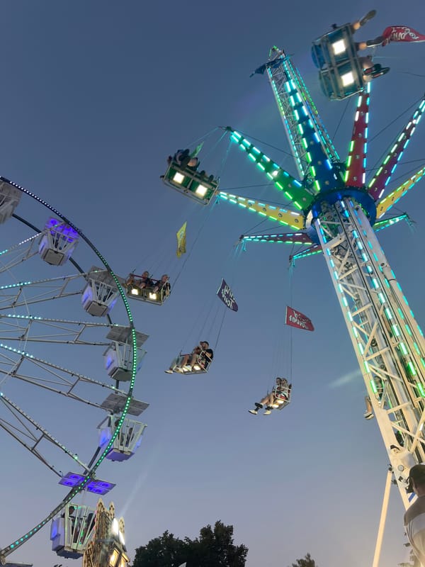 Fairground rides light up a summer evening in Tychy