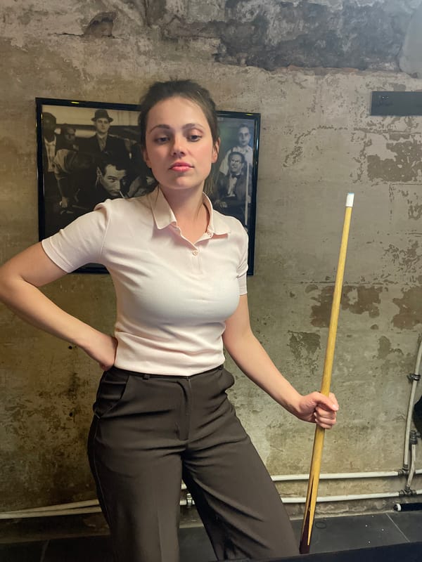Woman plays pool at underground Budapest bar Friday evening