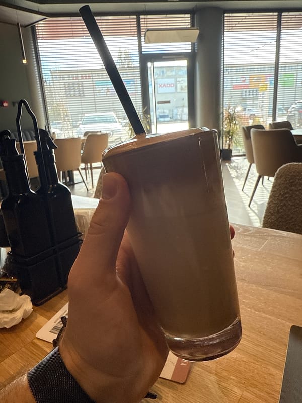 Person enjoys iced coffee at Sofia cafe