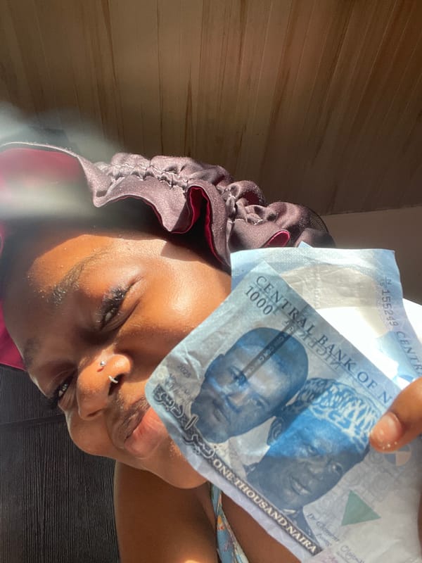 Person displays Nigerian Naira banknotes in Ado portrait photos