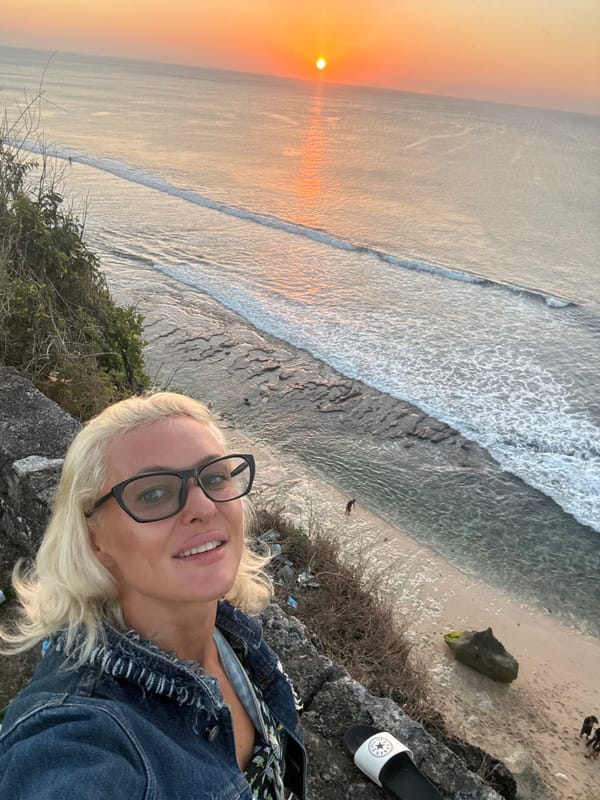 Cliffside ocean sunset, golden light across the water