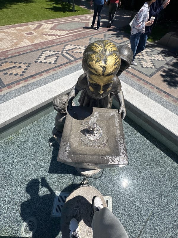 Bronze child statue at active fountain draws visitors in Yerevan