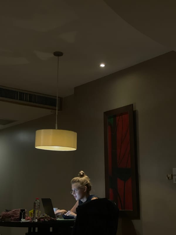 Blonde woman observed in dimly lit Bangkok room