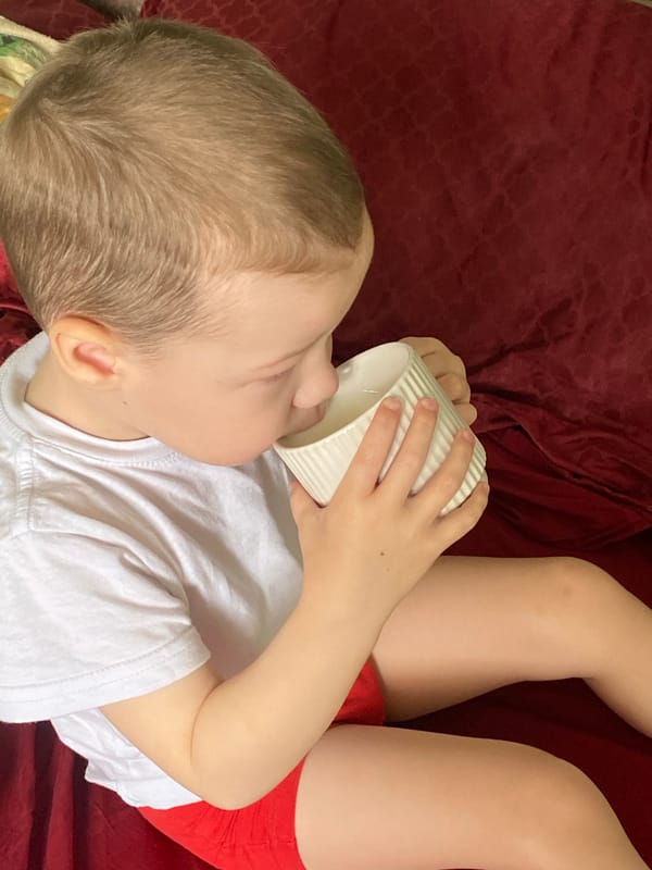 Child enjoys morning drink in bed, Sochi