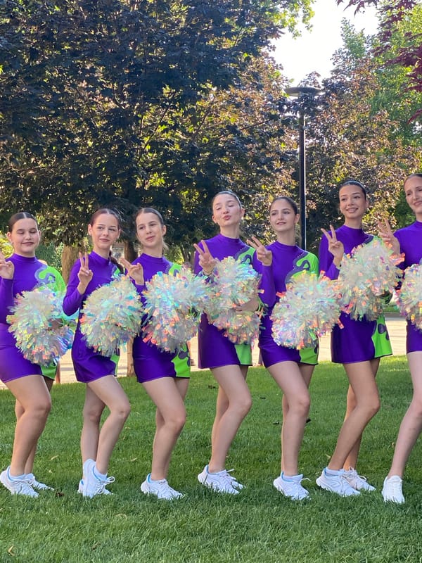 Cheerleading squad poses with pom-poms on Pleven lawn