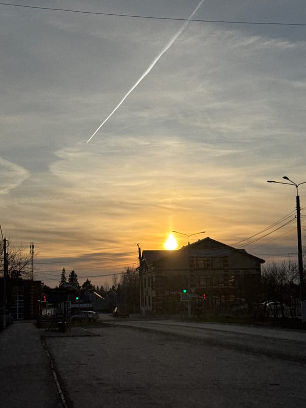 Sunset street scene with contrail observed in Chernushka, Russia
