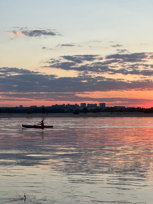 Kayaking into a sunset, with contrails overhead