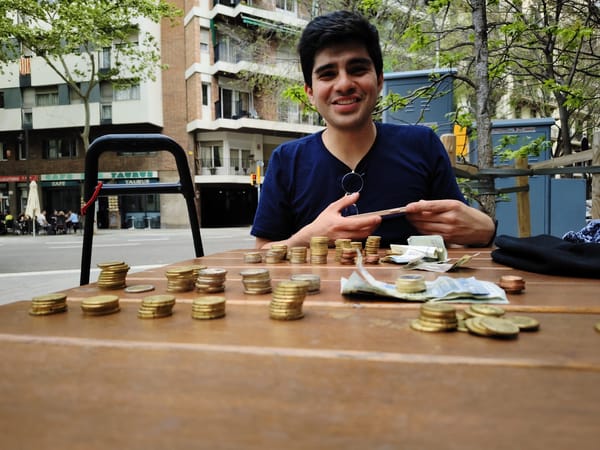 Man counts Euro currency at Barcelona park table