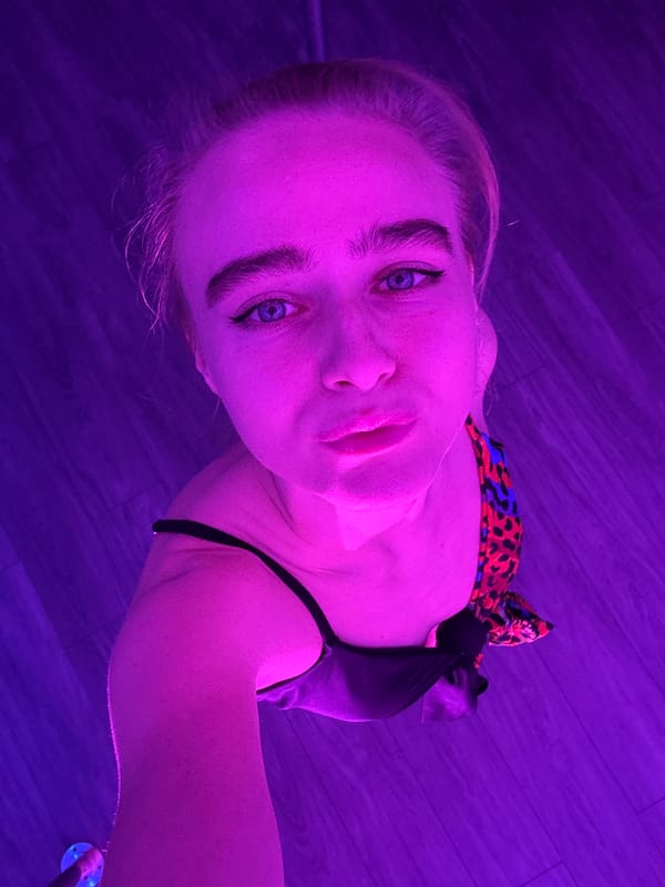 Pole dancing class observed at purple-lit studio