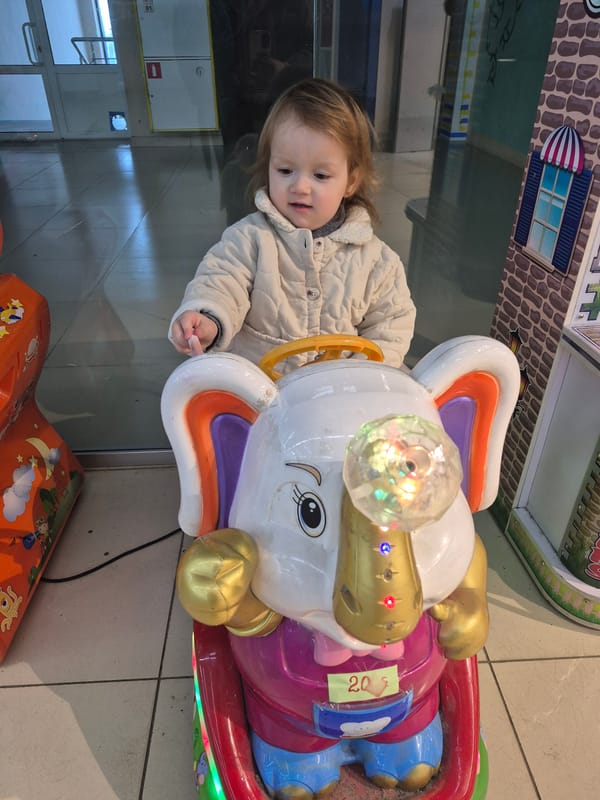Toddler enjoys arcade rides at indoor mall playground