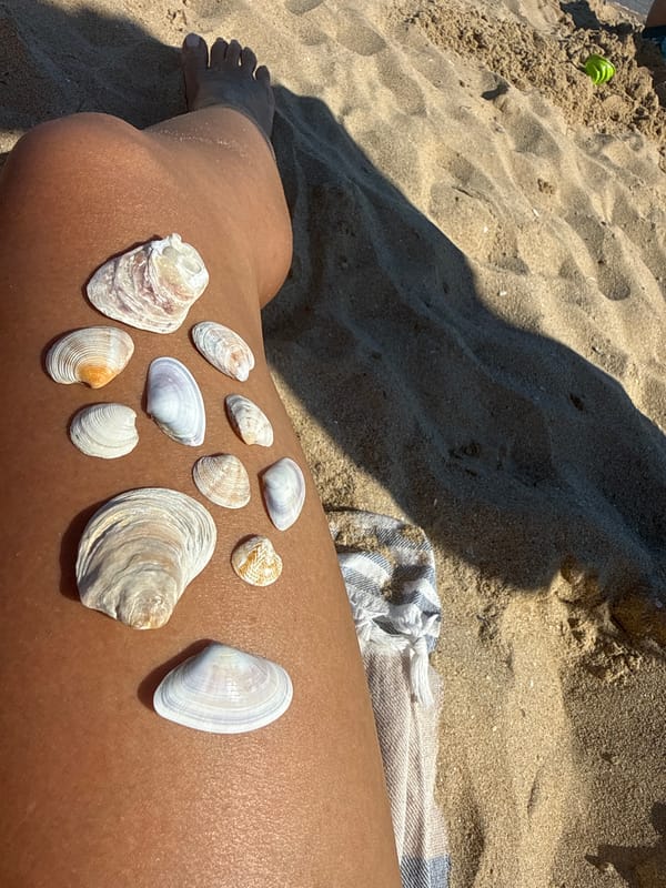 Seashells arranged on a sun-tanned leg at Nesebar beach