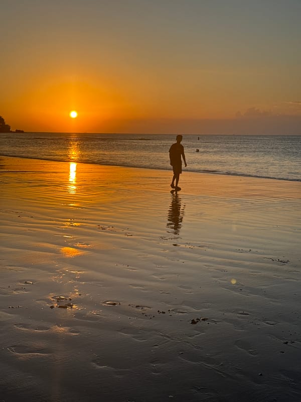 Sunset beach scene with crowds, games, and golden light