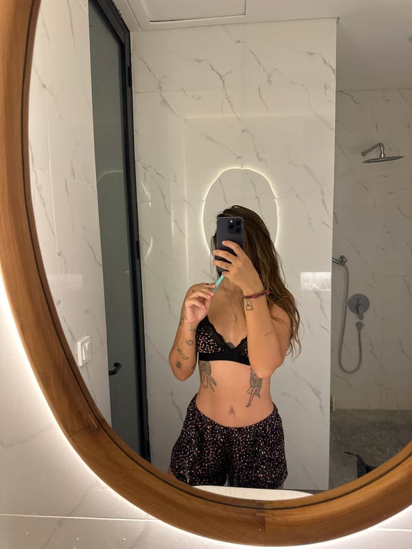 Woman takes bathroom mirror selfie in Mengwi, Indonesia