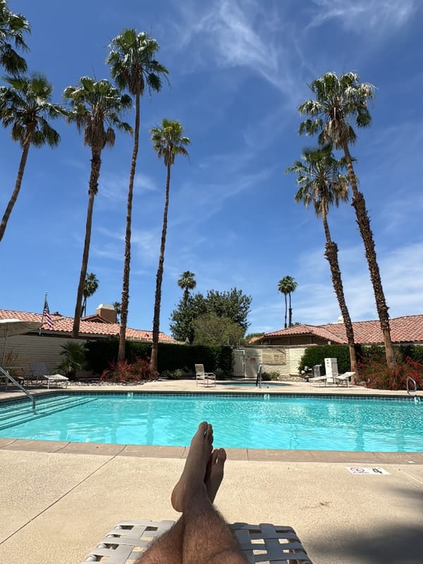 Person enjoys poolside relaxation in Palm Desert neighborhood