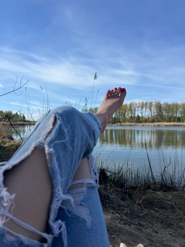 Person enjoys lakeside afternoon with beer in Ciemne, Poland