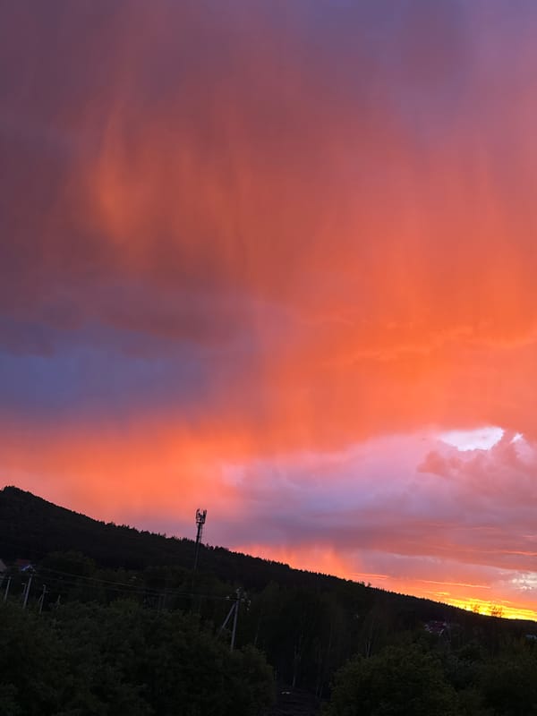 Dramatic sunset displays vibrant colors over rural landscape