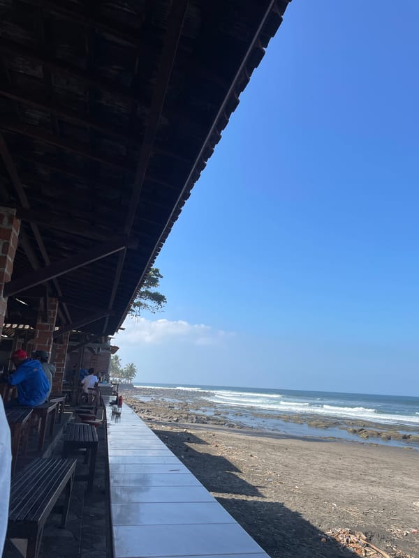 Dark sand beach and a cold drink in Pekutatan, Bali