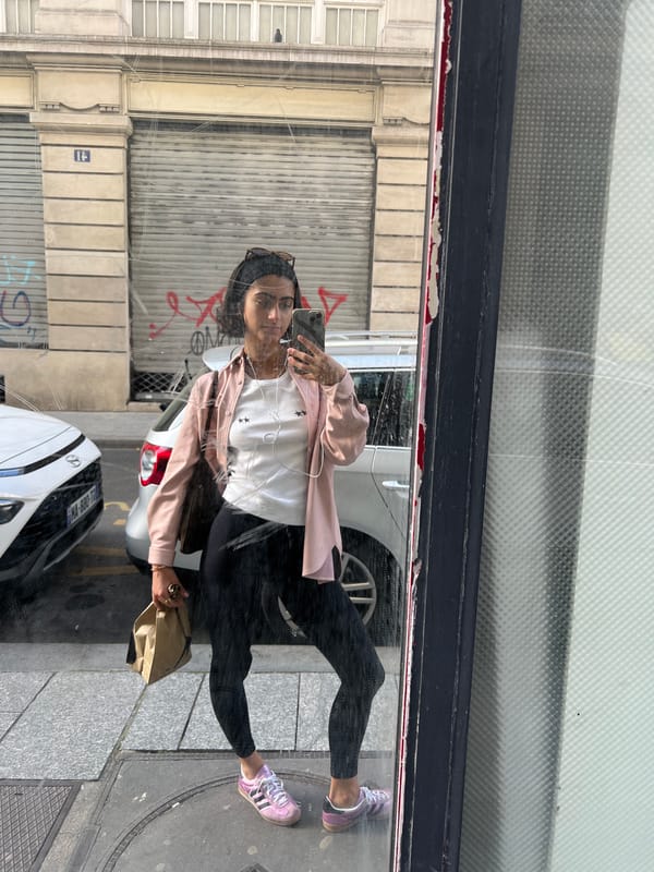Woman captures selfie in Paris shop window reflection