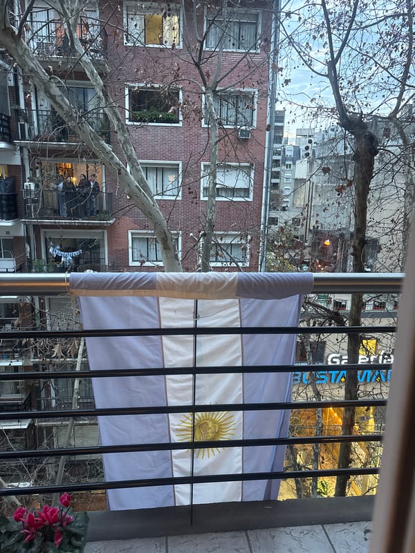 Watching football from a flag-draped Buenos Aires balcony