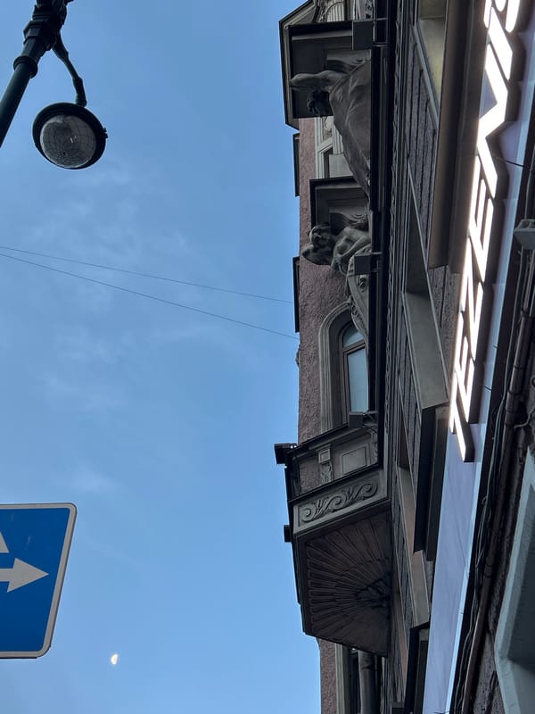 Street-level urban details: buildings, lampposts, and a pigeon