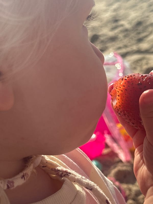 Child enjoys strawberries on Tel Aviv beach